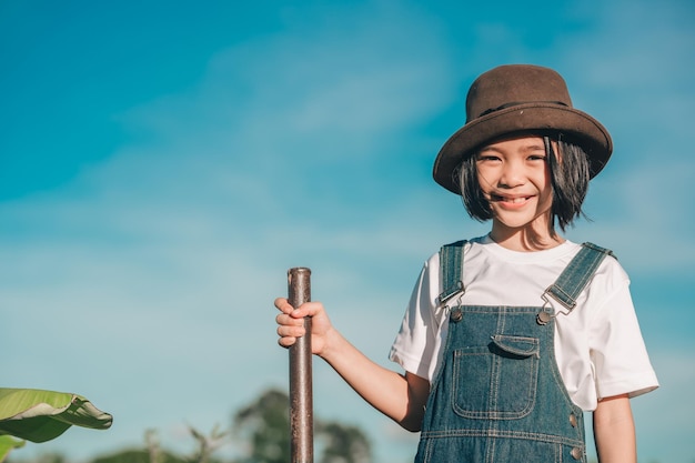 Crianças felizes sorriem e plantam a árvore na zona rural