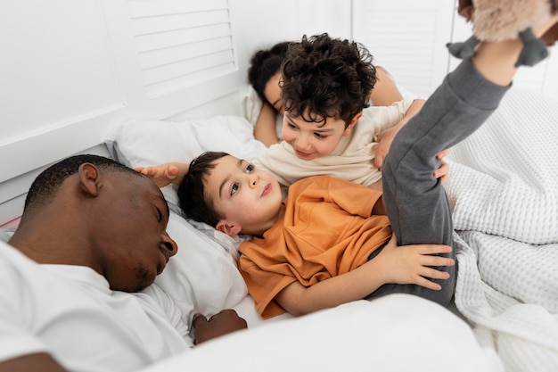 Crianças fofas tentando dormir com os pais