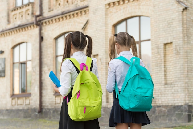 Crianças indo para colegiais com mochilas, conceito de setembro.