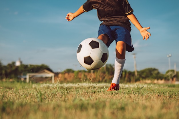 crianças jogando futebol futebol para se exercitar no campo de grama verde