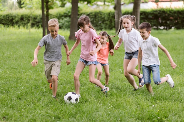 Crianças jogando futebol na grama