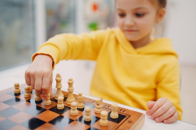 Crianças jogando xadrez no jardim de infância ou na escola primária
