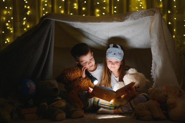 Crianças lendo história de ninar em casa