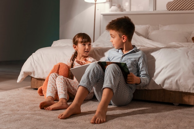 Crianças lendo histórias para dormir em casa