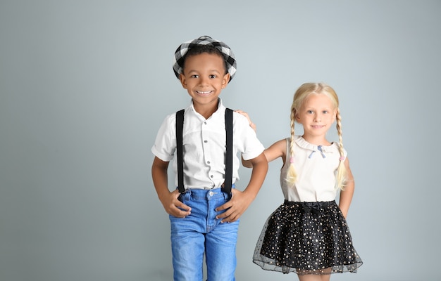 Foto crianças lindas e elegantes na superfície cinza