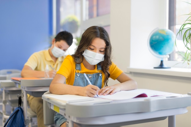 Foto crianças na escola com máscaras