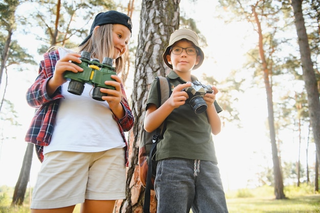 Crianças na floresta verde jogando conceito de férias e viagens para crianças