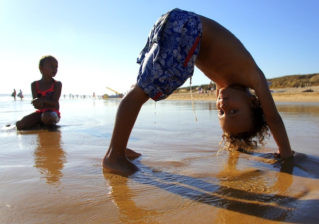 Crianças na praia ensolarada do Algarve