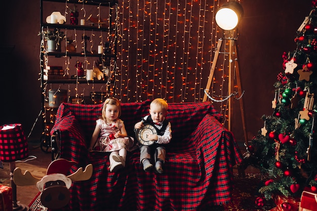 Crianças no estúdio decorado e brincando com presentes de natal