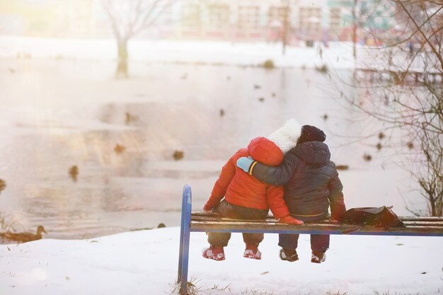 Crianças no parque de inverno brincam com a neve