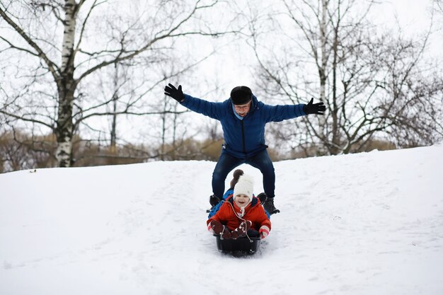 Crianças no parque no inverno. as crianças brincam com neve no parque infantil. eles esculpem bonecos de neve e deslizam pelas colinas.