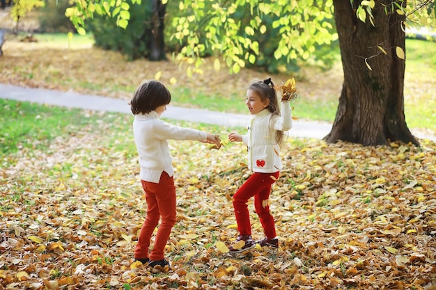 Crianças para passear no parque de outono Folha cai no parque Family Fall Happiness