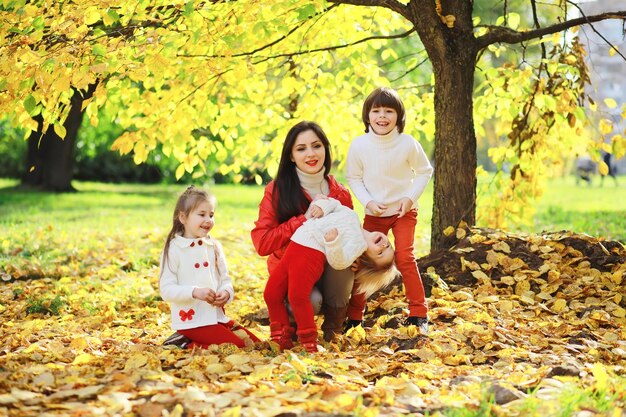 Crianças para um passeio no parque de outono. As folhas caem no parque. Família. Outono. Felicidade.