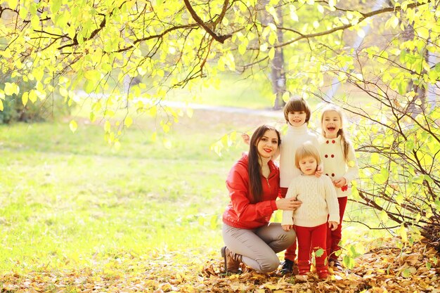 Crianças para um passeio no parque de outono. As folhas caem no parque. Família. Outono. Felicidade.