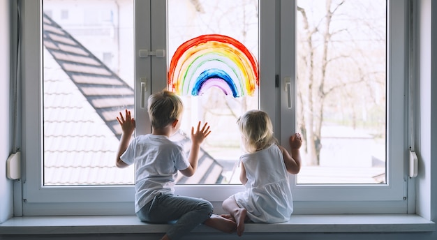 crianças pequenas no fundo da pintura do arco-íris na foto da janela do lazer infantil em casa