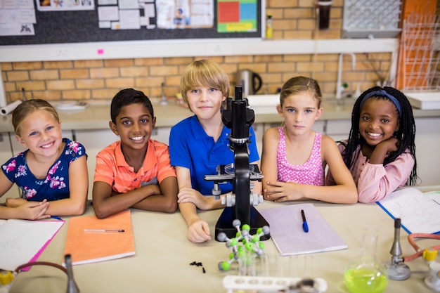 Foto crianças posando com microscópio