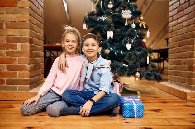 Crianças posando para árvore de natal