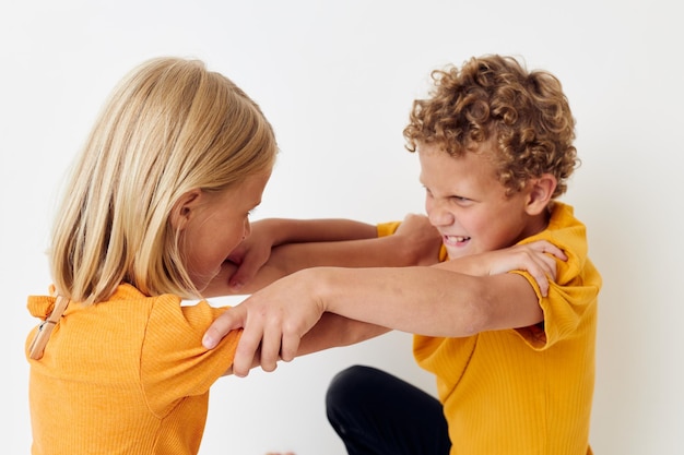 Crianças pré-escolares bonitas em camisetas amarelas de pé lado a lado emoções da infância inalteradas