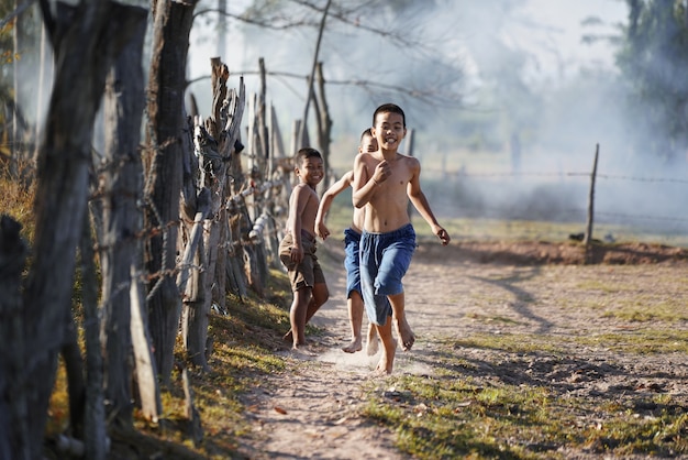 Crianças que correm no campo campo de Ásia.
