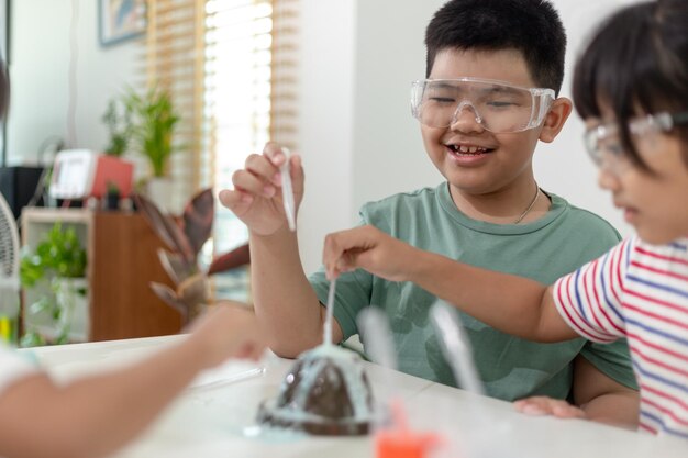 Crianças repetindo e observando um projeto de laboratório de ciências em casa, o vulcão de bicarbonato de sódio e vinagre