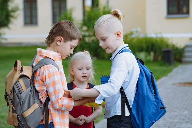 Crianças saindo da escola com mochilas Início do ano letivo Meninos na porta da escola
