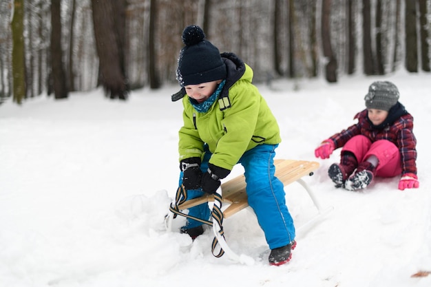 Foto crianças se divertindo andando de trenó brincando na neve