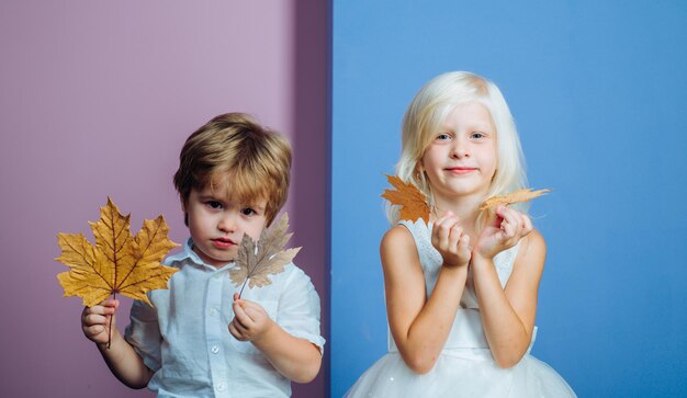 Crianças se divertindo com Leaf fall Os grandes descontos para todas as roupas de outono para crianças