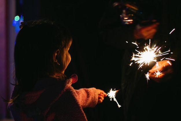 crianças se divertindo em uma festa de ano novo segurando brilho