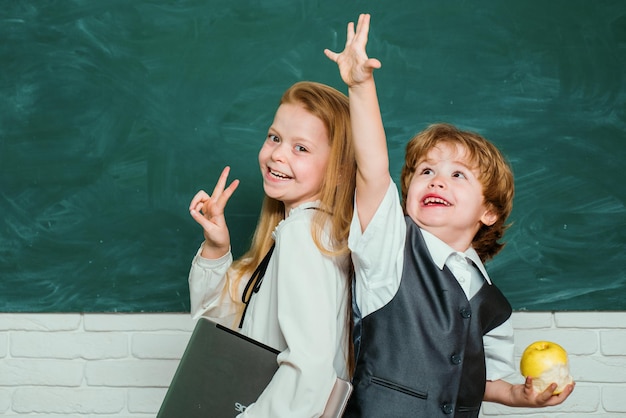 Crianças se preparam para a escola casal de garotinha e garotinha na sala de aula aluna ajudando alunos a estudar