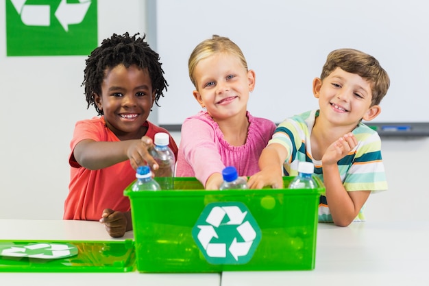 Foto crianças, segurando a garrafa reciclada na sala de aula