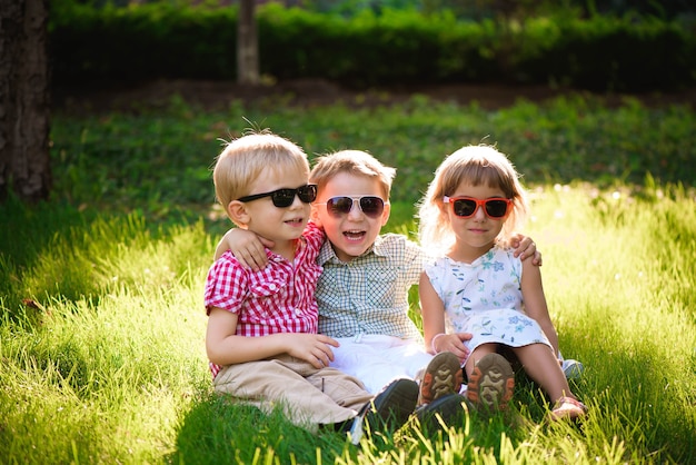 Crianças sorrindo no jardim de óculos escuros