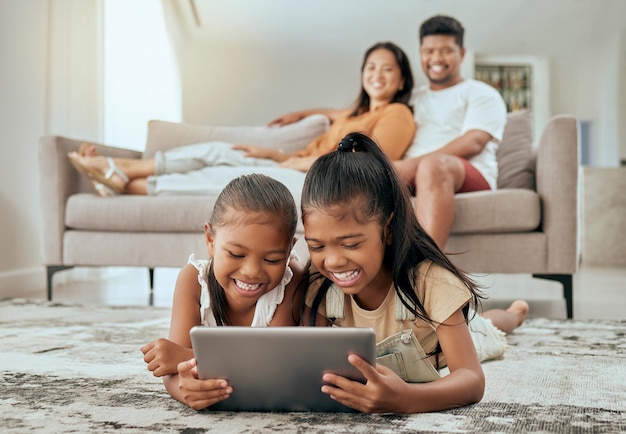 Mãe e filhos felizes com tablet digital assistem a vídeos engraçados,  filmes ou jogos no sofá