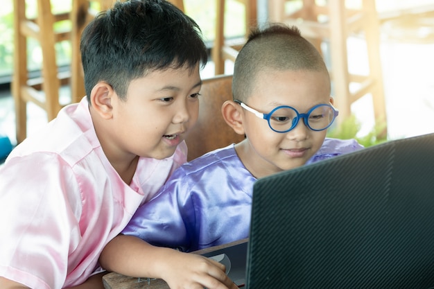 Crianças usando laptop desfrutar, feliz em casa. conceito de educação
