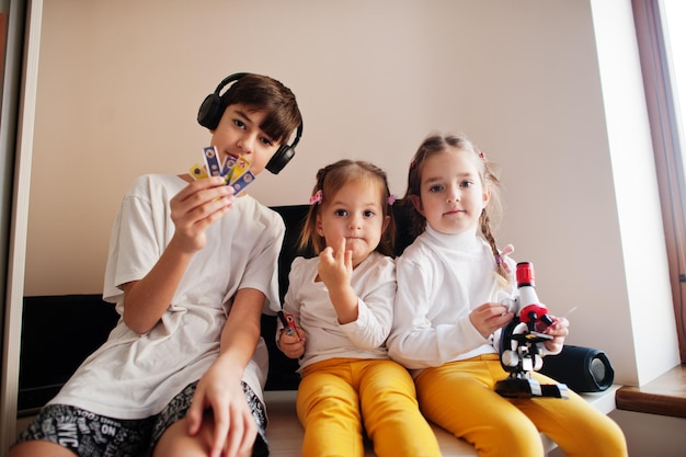 Crianças usando microscópio aprendendo aula de ciências em casa.