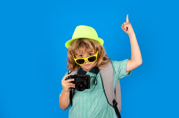 Crianças viajam Menino feliz com chapéu de viagem com câmera fotográfica isolada no fundo do estúdio Estilo de vida de viagem e sonhos de viagem