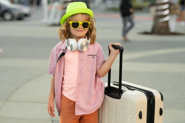Crianças viajando criança com mala saindo de férias menino turista no conceito de crianças de viagens de férias