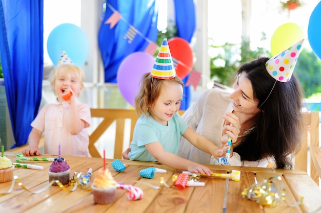 Criancinha e sua mãe comemoram a festa de aniversário com decoração colorida e bolos com decoração colorida e bolo