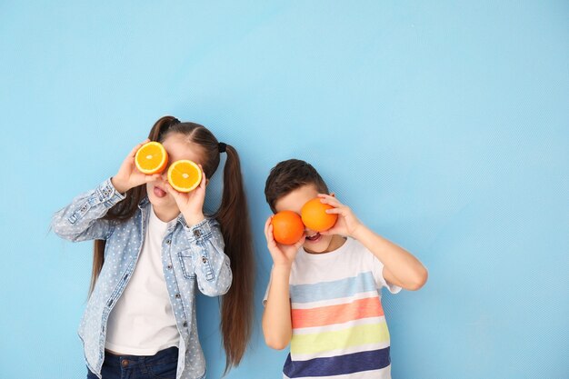 Criancinhas engraçadas com frutas cítricas coloridas