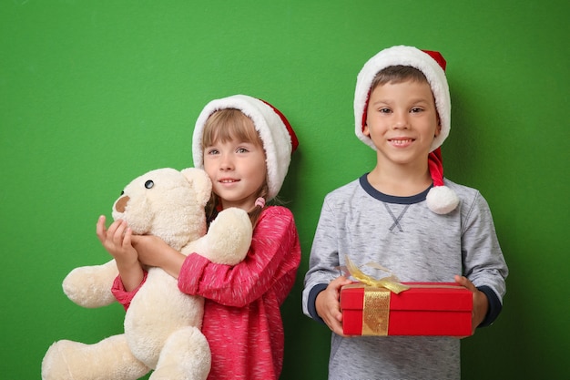 Criancinhas fofas com presentes de Natal na cor de fundo