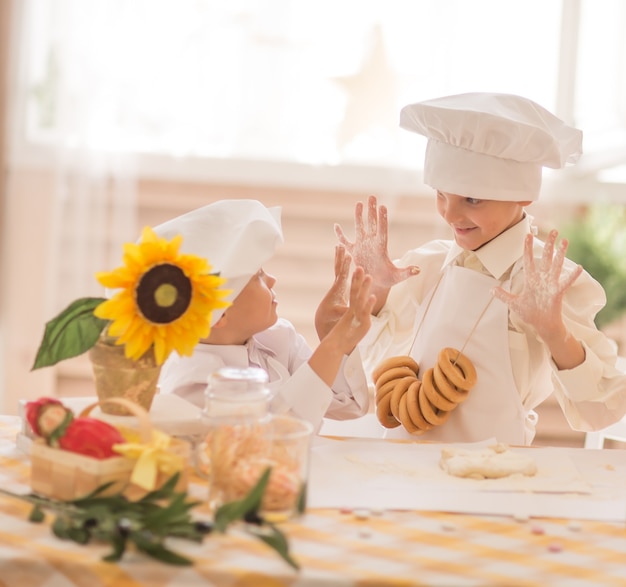 Criancinhas na forma de um chef para cozinhar uma deliciosa brincadeira entre si