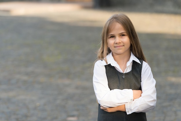 Criando o futuro das crianças. Criança de volta à escola. Criança pequena com uniforme formal ao ar livre. Educação primária. 1 de setembro. Dia do conhecimento. Ensino privado, copie o espaço.