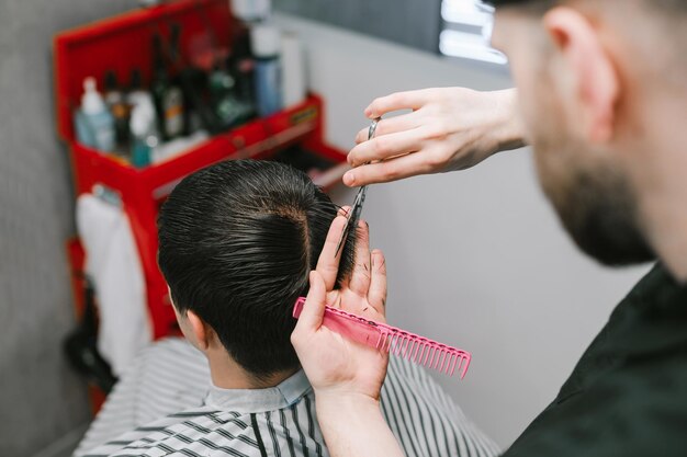 Criando um penteado masculino moderno com tesoura em um cabeleireiro masculino Closeup