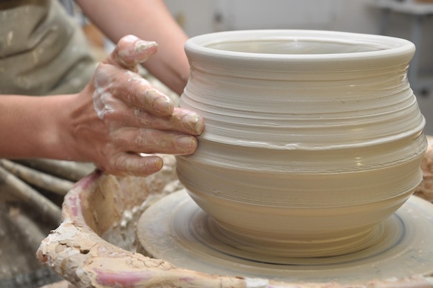 Criando um vaso de argila em uma roda de oleiro close-up