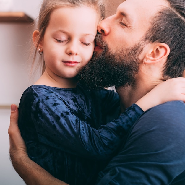 Crianza feliz. Retrato de padre mostrando amor y cuidado a su linda hijita.