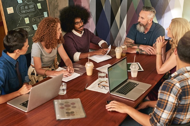 Criar e colaborar é o caminho para o sucesso Foto recortada de colegas criativos em uma reunião em um escritório moderno