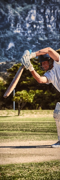 Foto cricketspieler, der während des sonnigen tages auf dem feld spielt