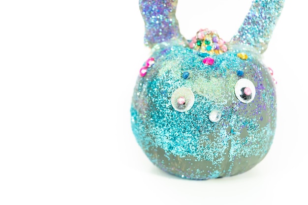 Crie uma abóbora de Halloween decorada como um coelho com orelhas e glitter por uma garotinha.