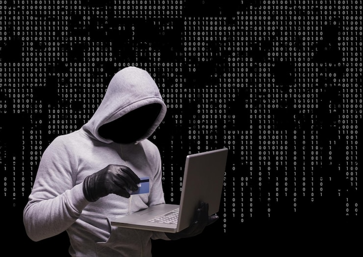 Foto criminal anónimo en el capó de la computadora portátil frente a los números