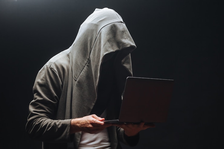Foto criminal con laptop en campana por la noche