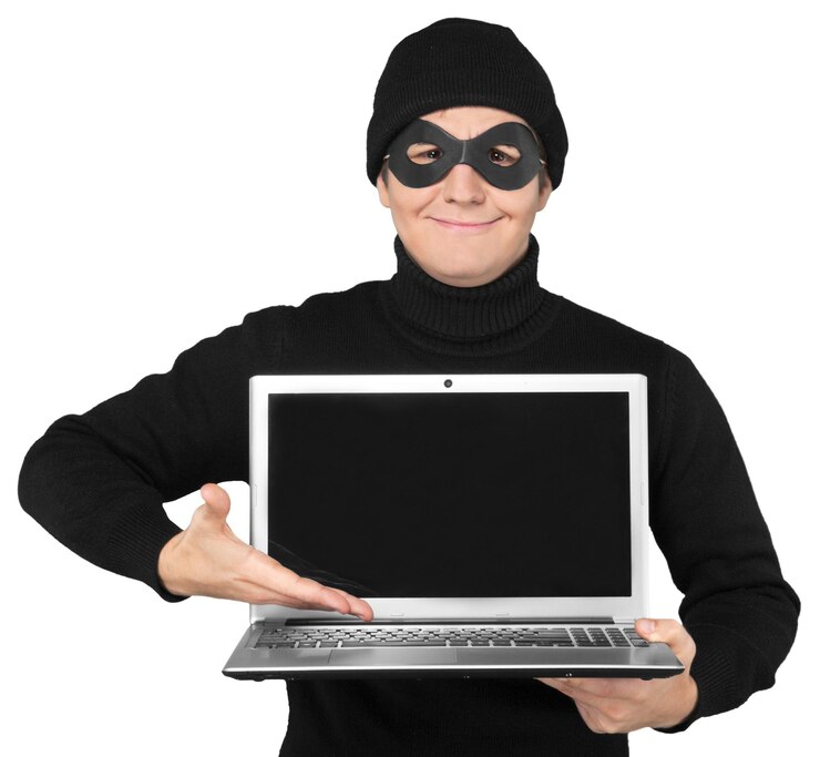 Foto criminal malvado en una máscara con portátil en el fondo